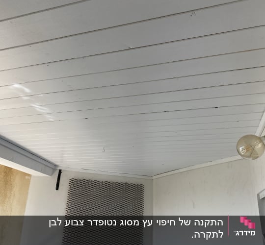 תקרה מעץ עם מנורה על הקיר